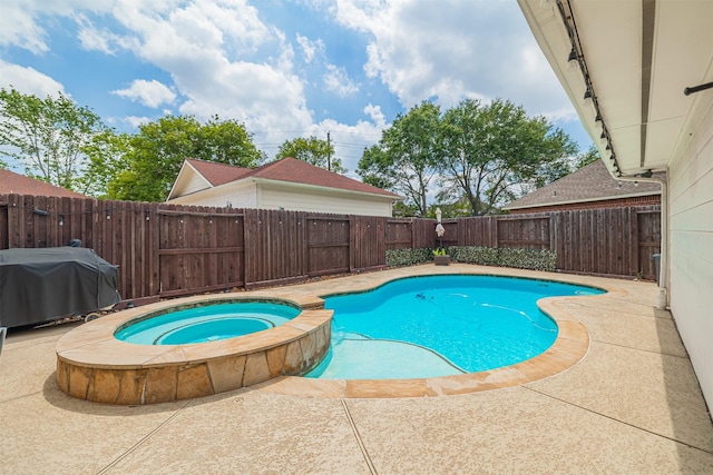 view of swimming pool with a fenced backyard, a pool with connected hot tub, area for grilling, and a patio