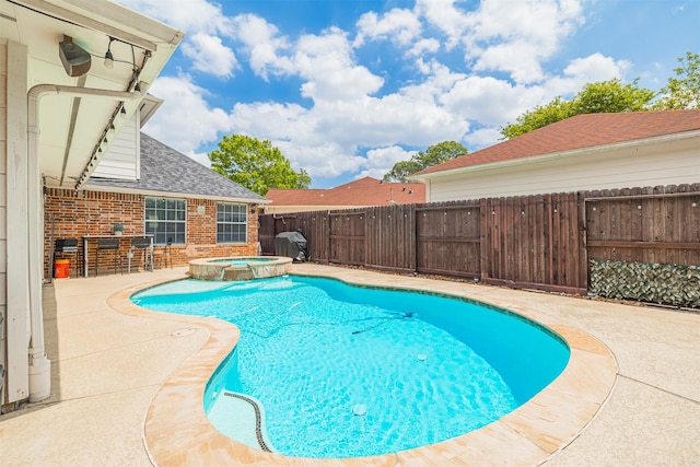 view of pool with a patio area, a fenced backyard, outdoor dry bar, and a pool with connected hot tub