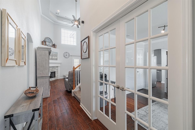hall featuring french doors, baseboards, a towering ceiling, wood finished floors, and stairs