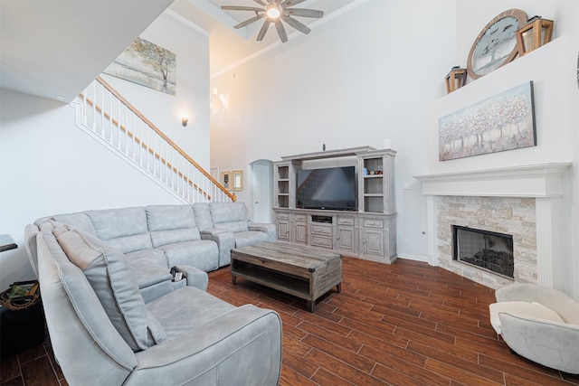 living area featuring dark wood-type flooring, stairway, a high ceiling, and a ceiling fan