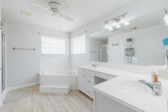 full bathroom featuring a shower stall, visible vents, ceiling fan, and a sink