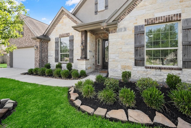 property entrance with a yard, stone siding, and concrete driveway