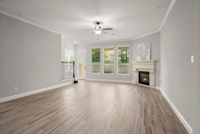 unfurnished living room featuring baseboards, a ceiling fan, a glass covered fireplace, and light wood-style flooring