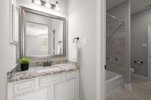full bath with vanity, baseboards, toilet, visible vents, and bathing tub / shower combination