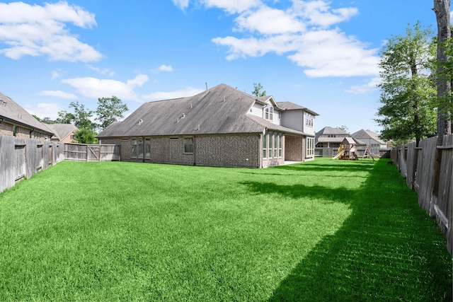 view of yard with a fenced backyard and a playground