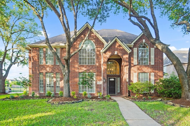 traditional-style house featuring brick siding and a front yard