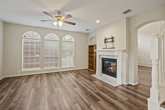 24126 Falcon Point Dr, Katy, TX 77494 - unfurnished living room with a ceiling fan, arched walkways, wood finished floors, baseboards, and a high end fireplace