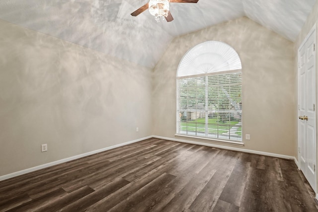 empty room with lofted ceiling, a ceiling fan, dark wood-type flooring, and baseboards
