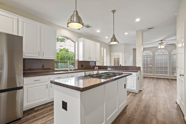 kitchen with wood finished floors, visible vents, a sink, appliances with stainless steel finishes, and white cabinetry