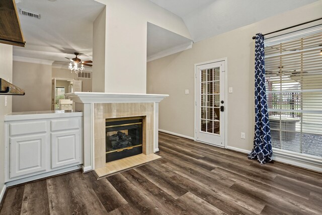 unfurnished living room with dark wood finished floors, a tiled fireplace, visible vents, and a ceiling fan
