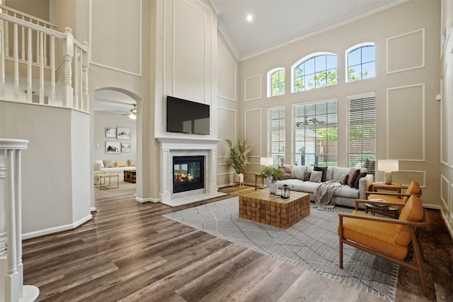 24126 Falcon Point Dr, Katy, TX 77494 - living room featuring ornamental molding, a fireplace, a high ceiling, ceiling fan, and wood finished floors
