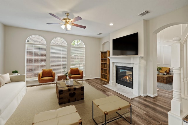 24126 Falcon Point Dr, Katy, TX 77494 - living area with a premium fireplace, ceiling fan, arched walkways, wood finished floors, and recessed lighting