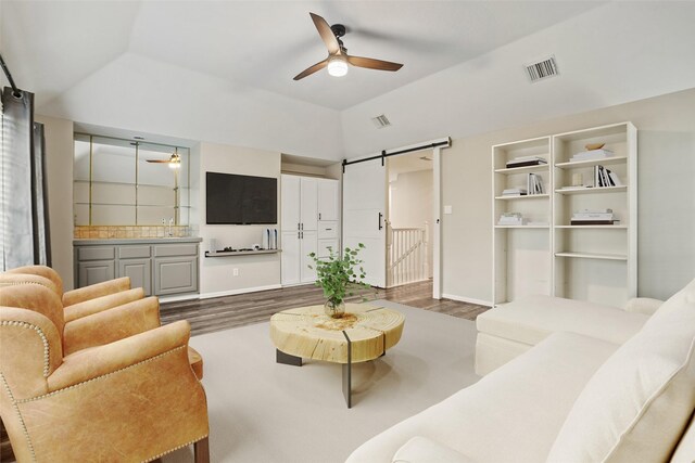 24126 Falcon Point Dr, Katy, TX 77494 - living room featuring a barn door, dark wood-type flooring, ceiling fan, baseboards, and high vaulted ceiling