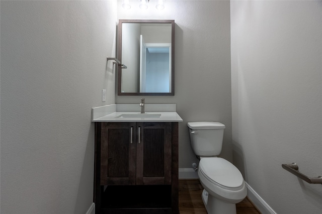 809 Coronado Terrace Ln, Katy, TX 77493 - half bathroom featuring vanity, toilet, wood finished floors, and baseboards