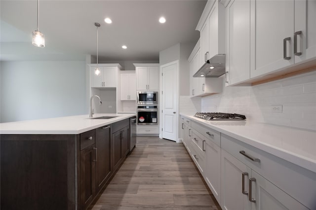 809 Coronado Terrace Ln, Katy, TX 77493 - kitchen with stainless steel appliances, a sink, dark brown cabinetry, decorative backsplash, and recessed lighting