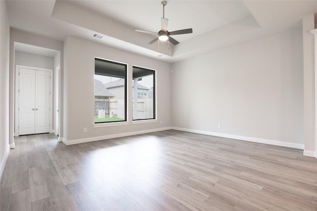 809 Coronado Terrace Ln, Katy, TX 77493 - unfurnished room with a tray ceiling, light wood-style flooring, a ceiling fan, and baseboards
