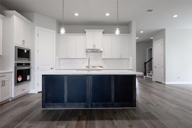 809 Coronado Terrace Ln, Katy, TX 77493 - kitchen featuring oven, built in microwave, backsplash, dark wood-type flooring, and recessed lighting