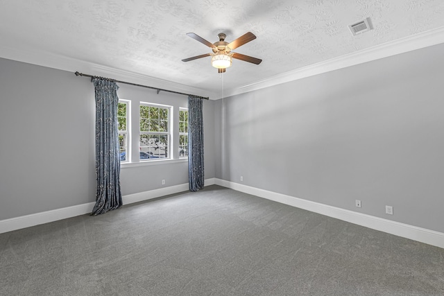 carpeted spare room with a ceiling fan, a textured ceiling, baseboards, ornamental molding, and visible vents
