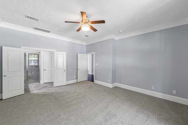 unfurnished bedroom featuring carpet floors, visible vents, baseboards, and ornamental molding