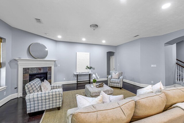 living area featuring visible vents, baseboards, arched walkways, and recessed lighting