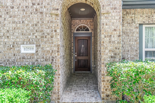 doorway to property with brick siding