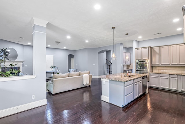 kitchen with dark wood finished floors, arched walkways, visible vents, and baseboards