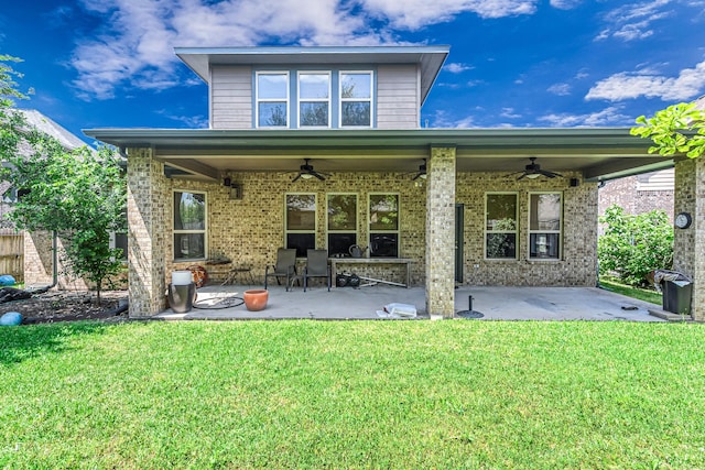 back of property featuring a lawn, brick siding, a patio, and ceiling fan