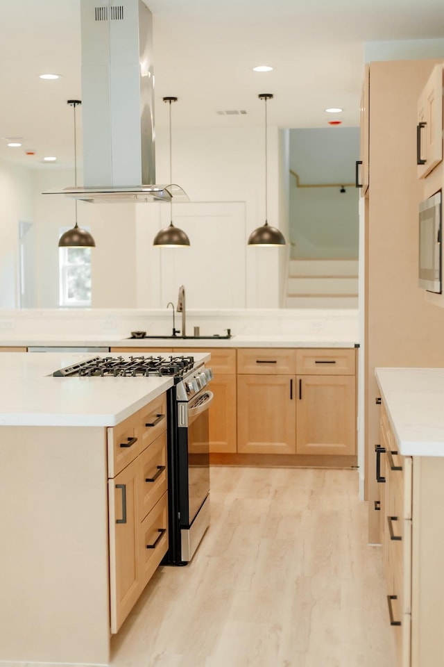 2711 Delano St, Houston, TX 77004 - kitchen featuring light brown cabinets, appliances with stainless steel finishes, island range hood, light wood-style floors, and light countertops