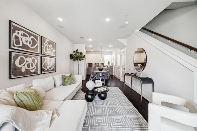 living room with recessed lighting and dark wood-style flooring