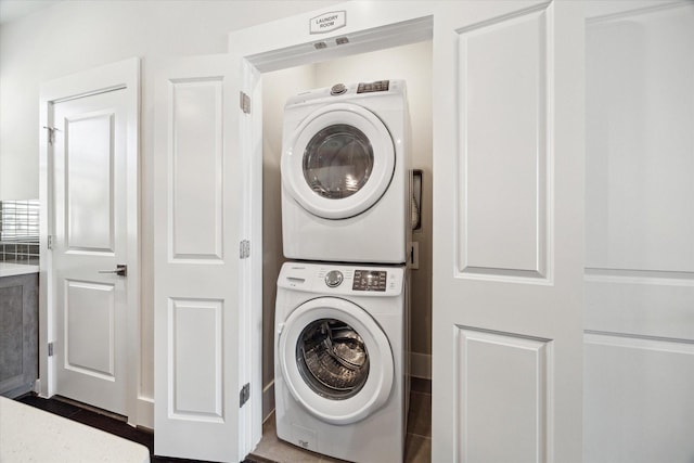 washroom with stacked washer and clothes dryer and laundry area