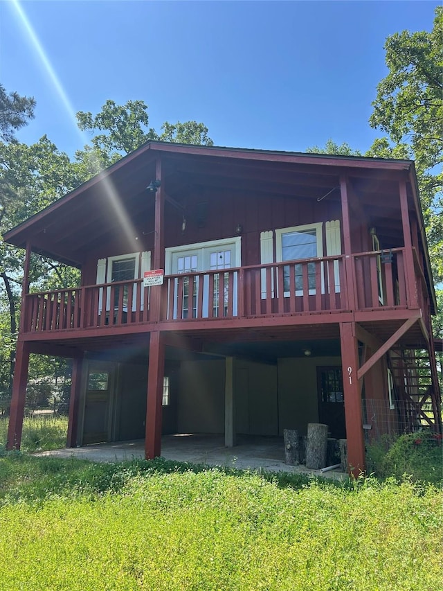 back of property with a yard and a deck