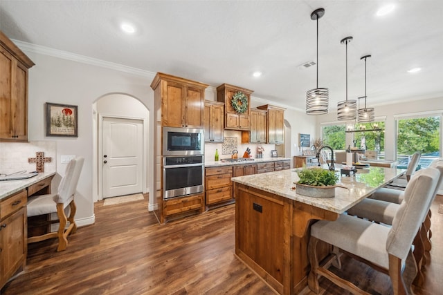 kitchen featuring crown molding, tasteful backsplash, arched walkways, stainless steel appliances, and visible vents