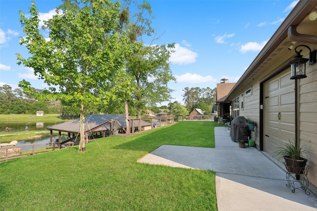 view of yard with fence, a water view, a patio, and a gazebo