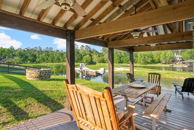 wooden deck featuring a yard, a water view, and a ceiling fan