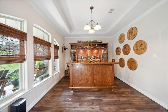 bar with a bar, a chandelier, pendant lighting, a raised ceiling, and dark wood-style floors