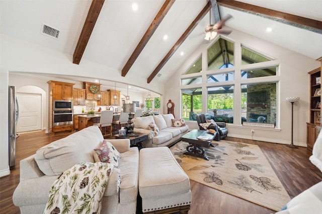 living area with arched walkways, visible vents, high vaulted ceiling, and ceiling fan