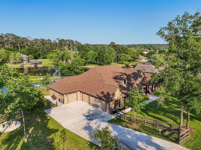 drone / aerial view featuring a forest view and a water view