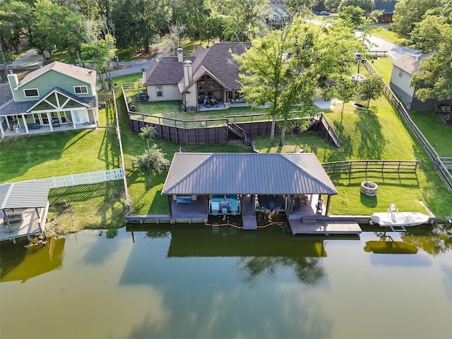 view of dock featuring a fenced backyard, a water view, and boat lift