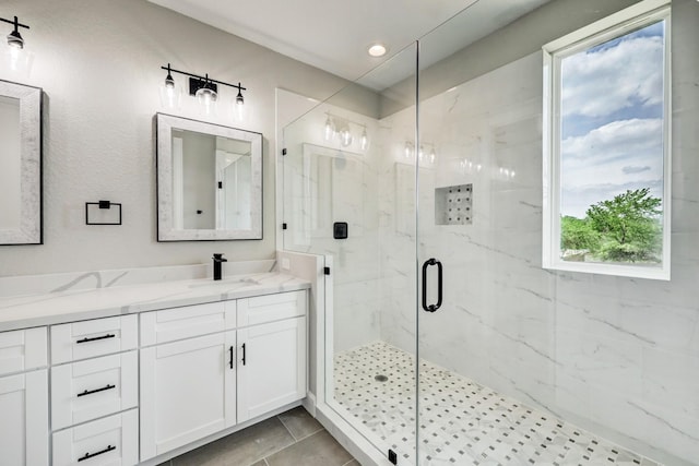 full bathroom featuring vanity, a marble finish shower, and recessed lighting