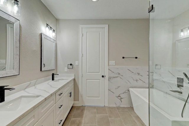 full bathroom with a soaking tub, a sink, tile patterned flooring, and double vanity
