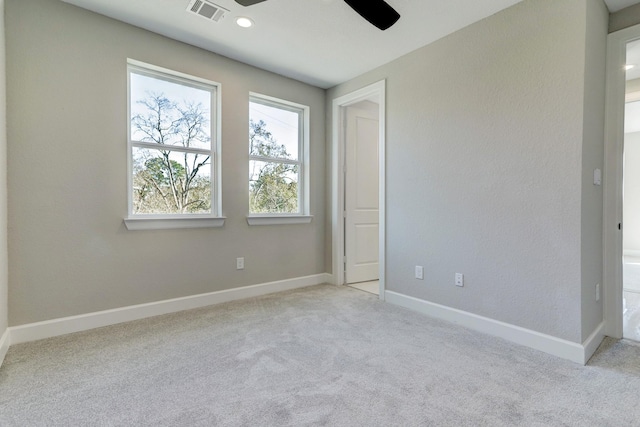unfurnished bedroom with baseboards, visible vents, light colored carpet, and ceiling fan