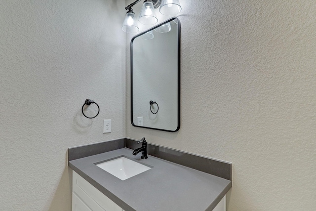 bathroom featuring a textured wall and vanity