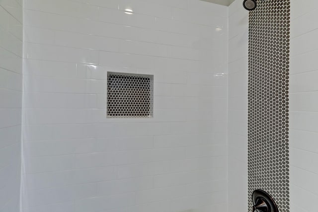 interior details featuring tiled shower