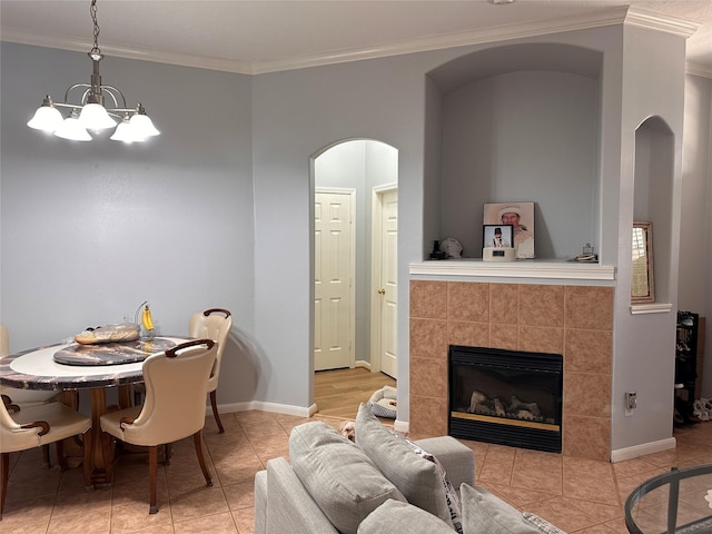 dining space with arched walkways, crown molding, baseboards, and light tile patterned flooring