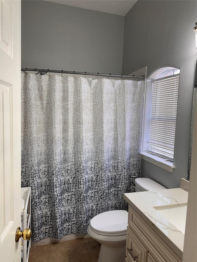 bathroom featuring curtained shower, toilet, vanity, and tile patterned floors
