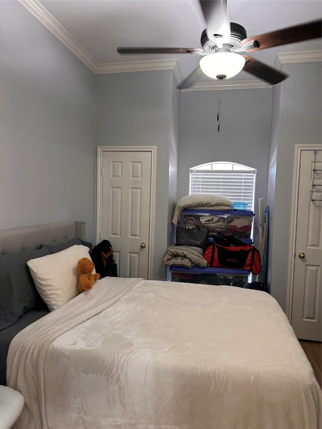 bedroom featuring a ceiling fan, ornamental molding, and wood finished floors