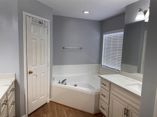 bathroom featuring vanity, wood finished floors, and a jetted tub