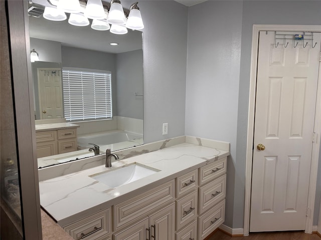 bathroom with a bath, vanity, and visible vents