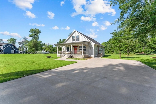view of front of house featuring driveway, a porch, board and batten siding, and a front yard