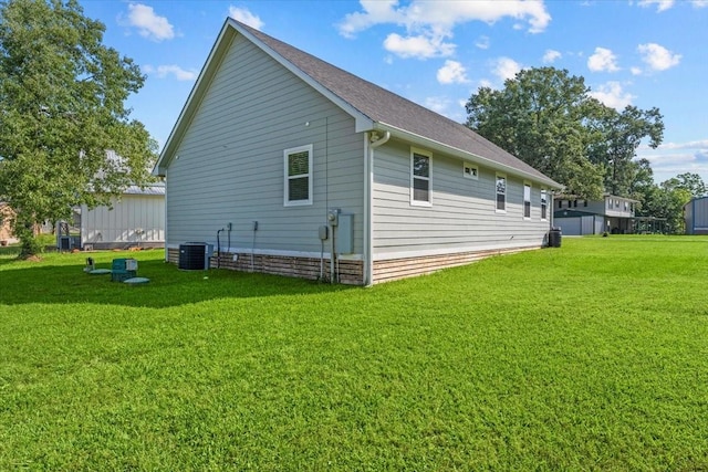 view of side of property featuring a lawn and central AC unit